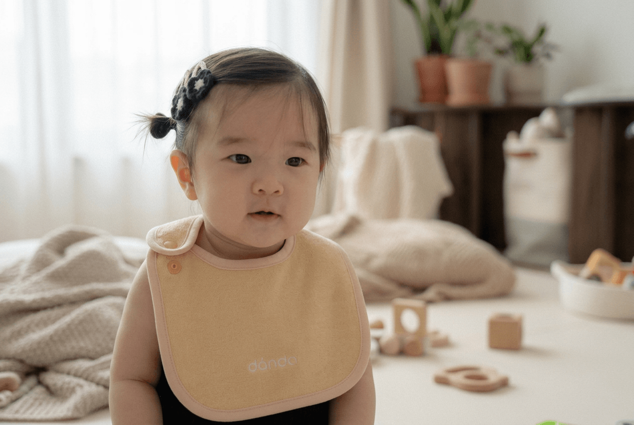 A baby wrapped in dánda soft-washed cotton in a calm home setting